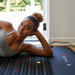 Woman lying on a HEALIX mat in a home setting