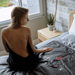 Woman sitting on a bed with a 'HEALIX' blanket in a bedroom setting.