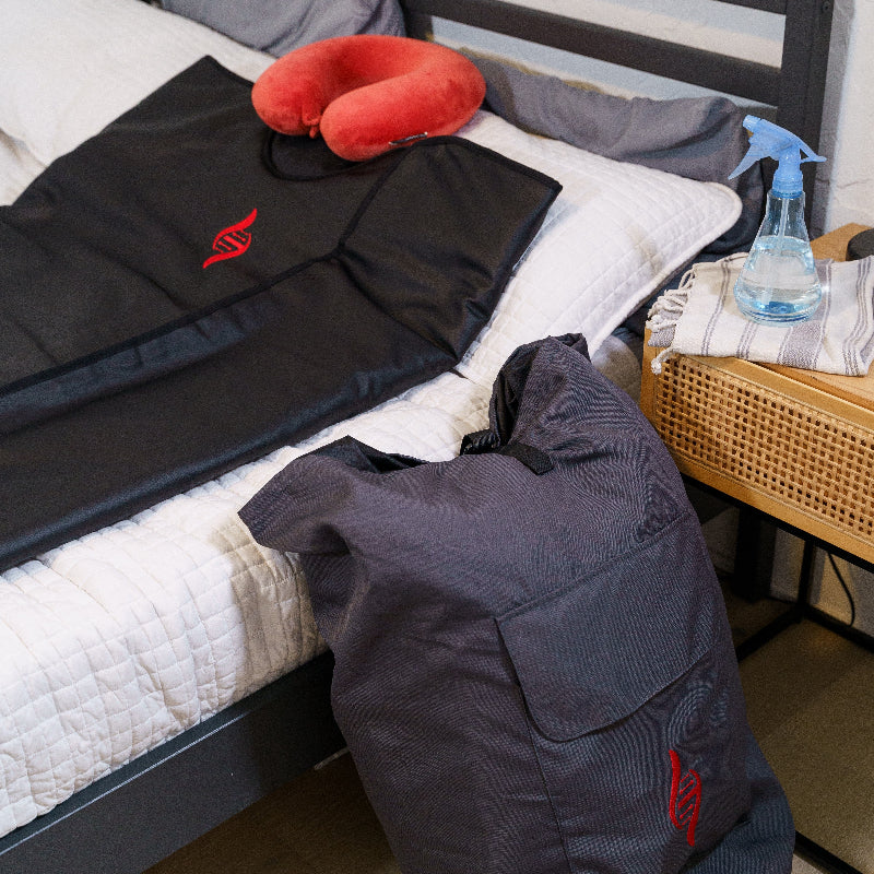 Black healix sauna blanket withcarrying bed next to bed