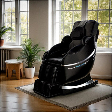 Black massage chair in a room with large windows and plants