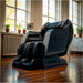Black massage chair in a room with large windows and plants