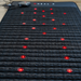 Black massage mat with red LED lights on a wooden surface therapy