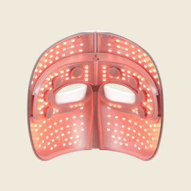 Pink LED face mask on a beige background