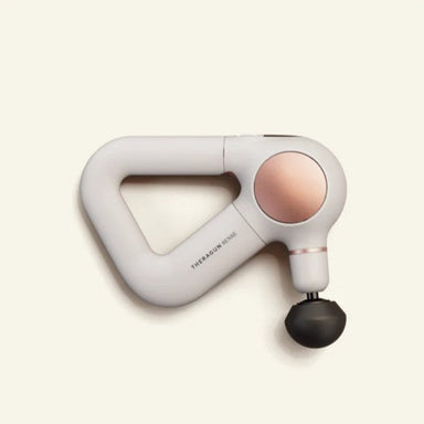 White handheld massage tool with a black end on a light beige background