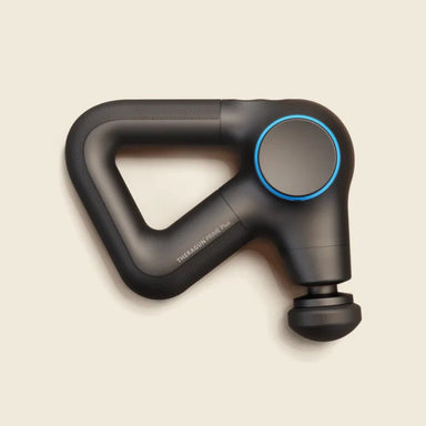 Black handheld massage gun on a beige background