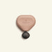 Heart-shaped device with 'Therabody' branding on a beige background