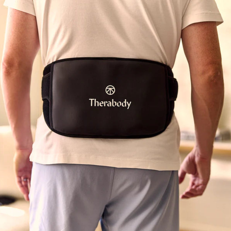 Person wearing a Therabody waist support belt in a home setting