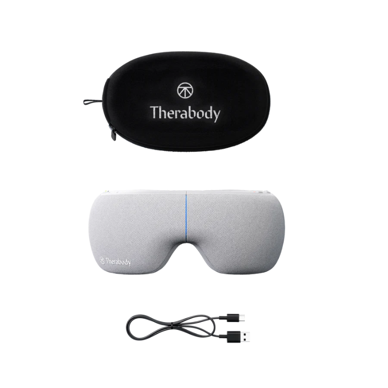 Gray eye pillow with black carrying case and USB cable on a white background, featuring Therabody branding.